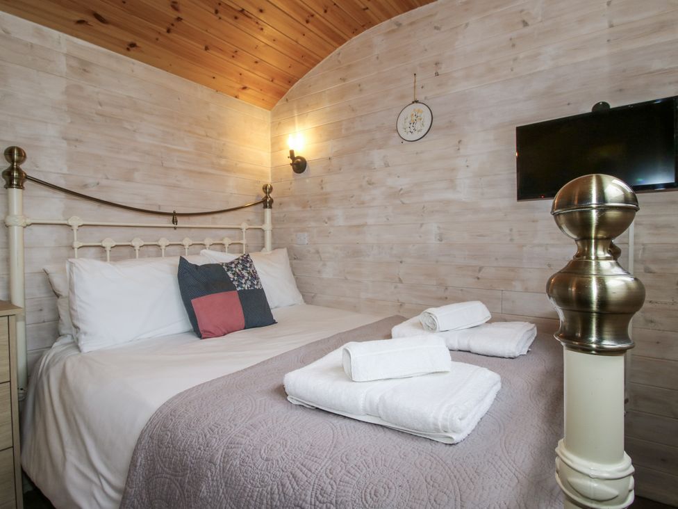 A bedroom with a bed and towels at Aston - Shepherd Hut in Aston On Clun
