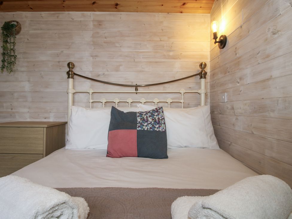 A bedroom with a bed and a nightstand at Aston - Shepherd Hut in Aston On Clun