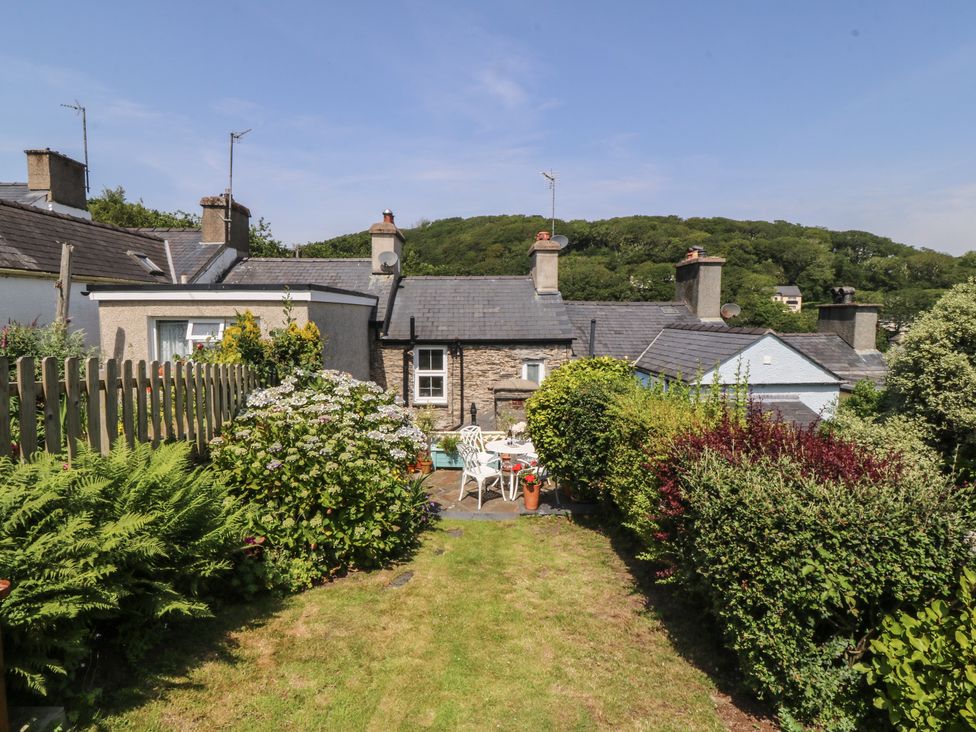 A garden with cottage view and patio furniture at Maenllwyd in Borth-Y-Gest near Porthmadog