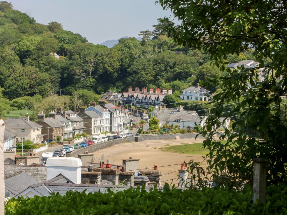 A view of houses along a road with trees in Borth-Y-Gest near Porthmadog
