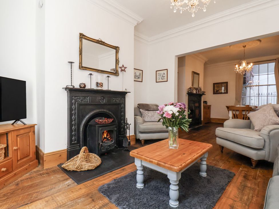 A living room with a fireplace and seating area at Charlotte House in Whitby