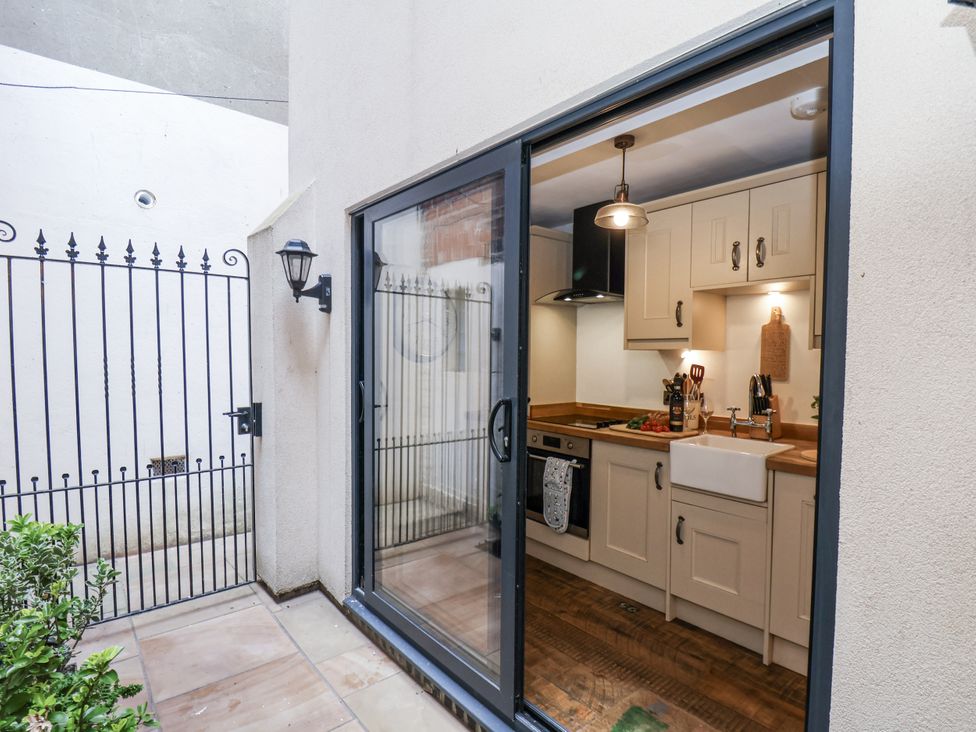 A kitchen with a view of a gated area at Charlotte House in Whitby