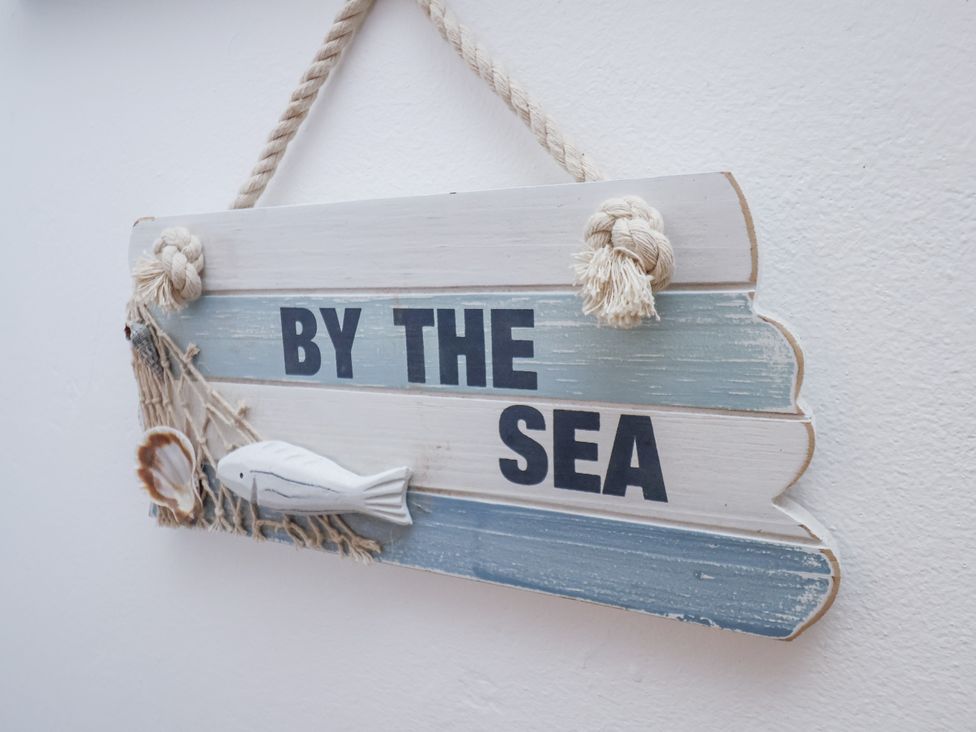 A decorative sign with the text 'BY THE SEA' at Charlotte House in Whitby