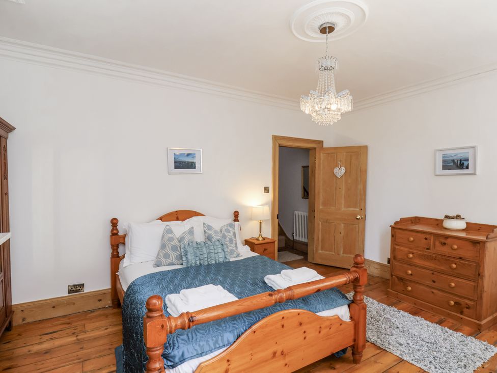 A bedroom with a bed and wooden furniture at Charlotte House in Whitby