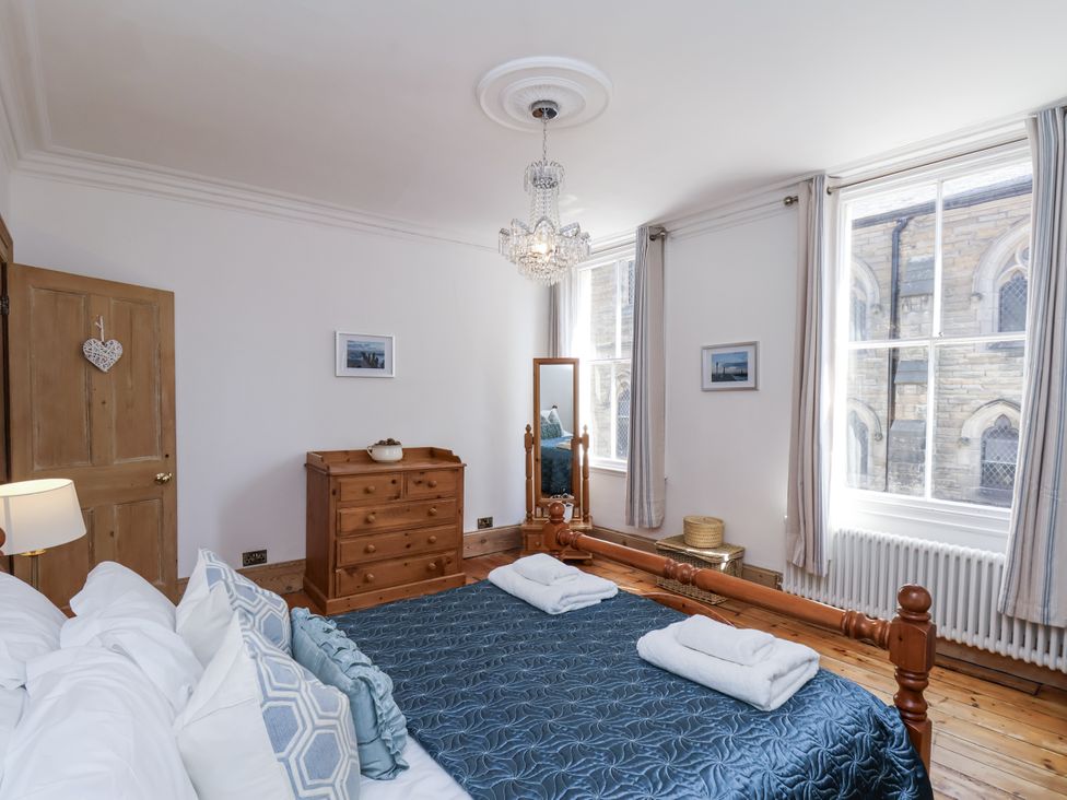 A bedroom with a bed and a dressing table at Charlotte House in Whitby
