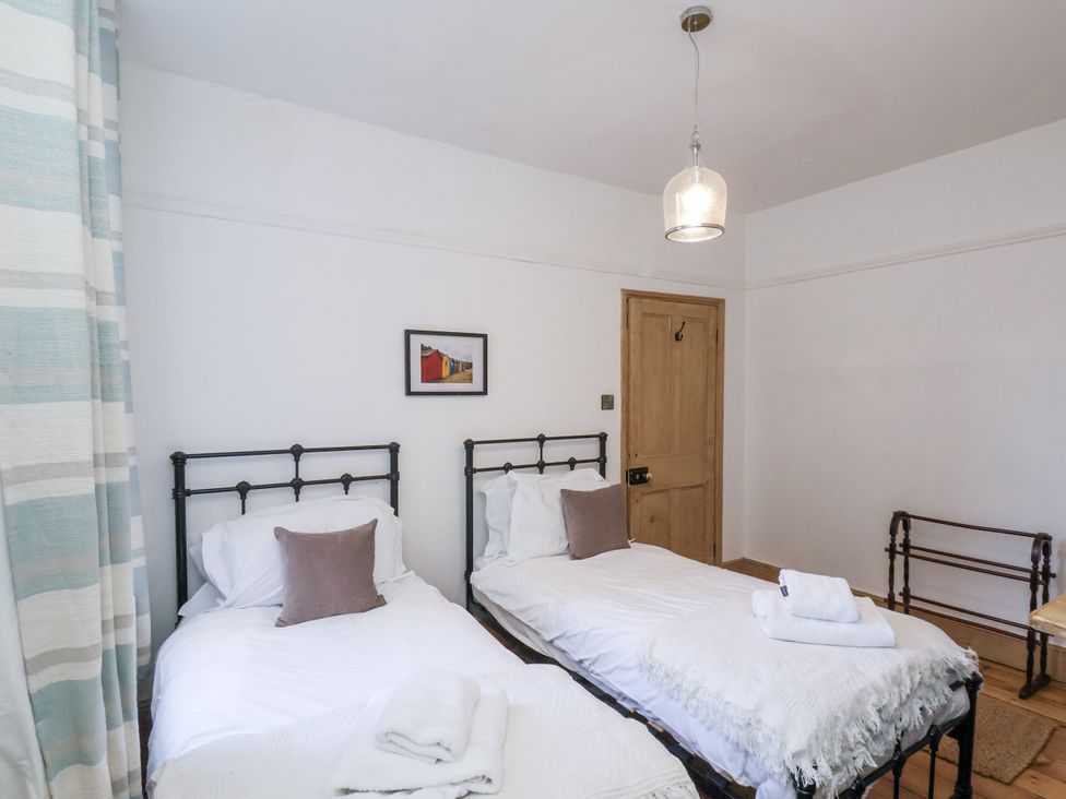 A bedroom with two single beds and a painting at Charlotte House in Whitby