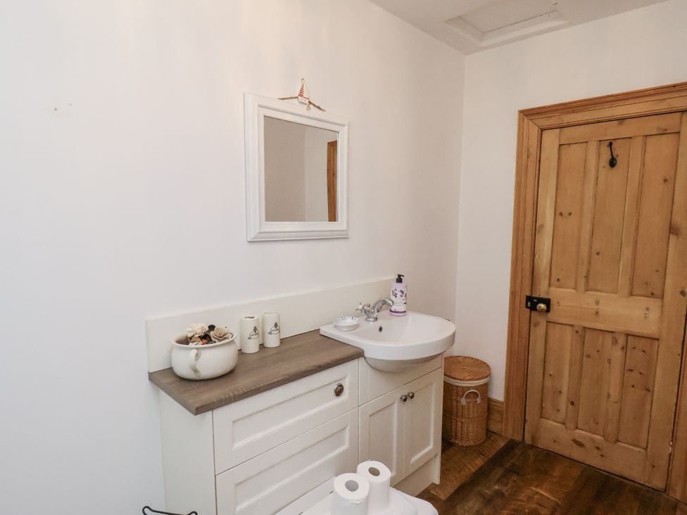 A bathroom with a sink and mirror at Charlotte House in Whitby