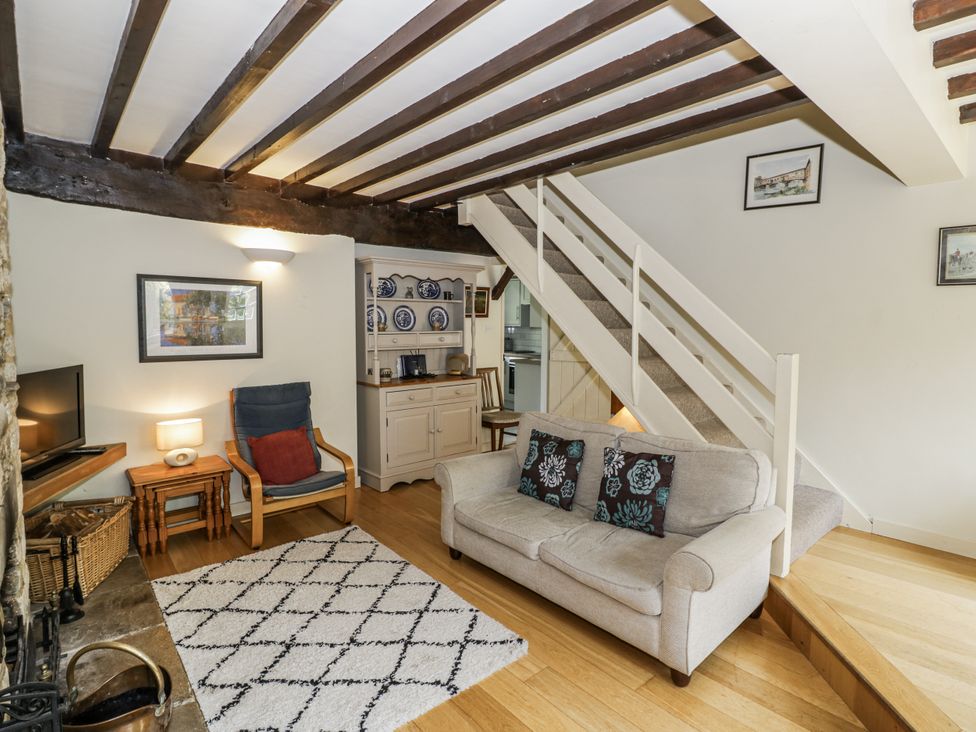 A living room with a sofa and television at Dairy Cottage in Witney