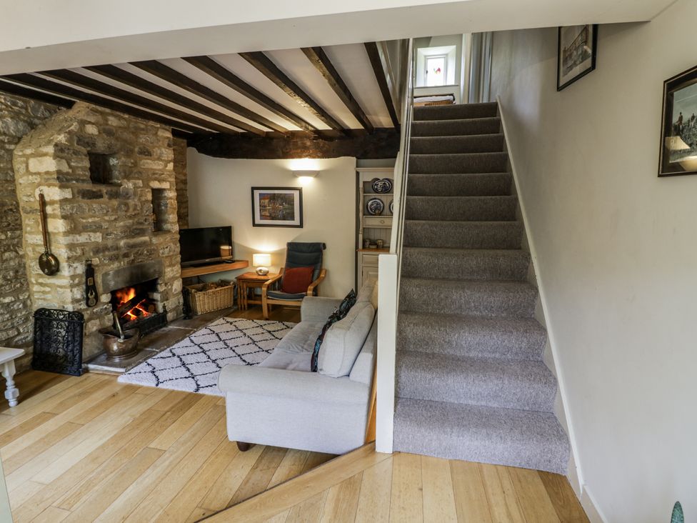 A living room with a sofa and television at Dairy Cottage in Witney