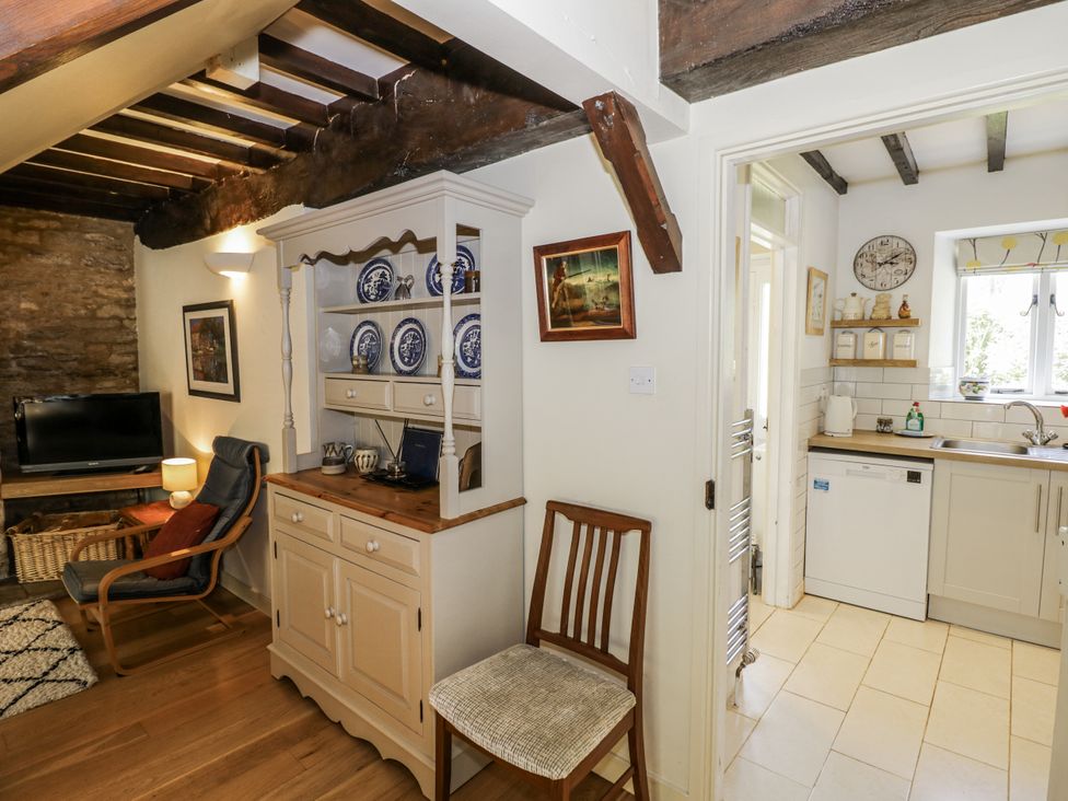 A living room with a television and armchair at Dairy Cottage in Witney