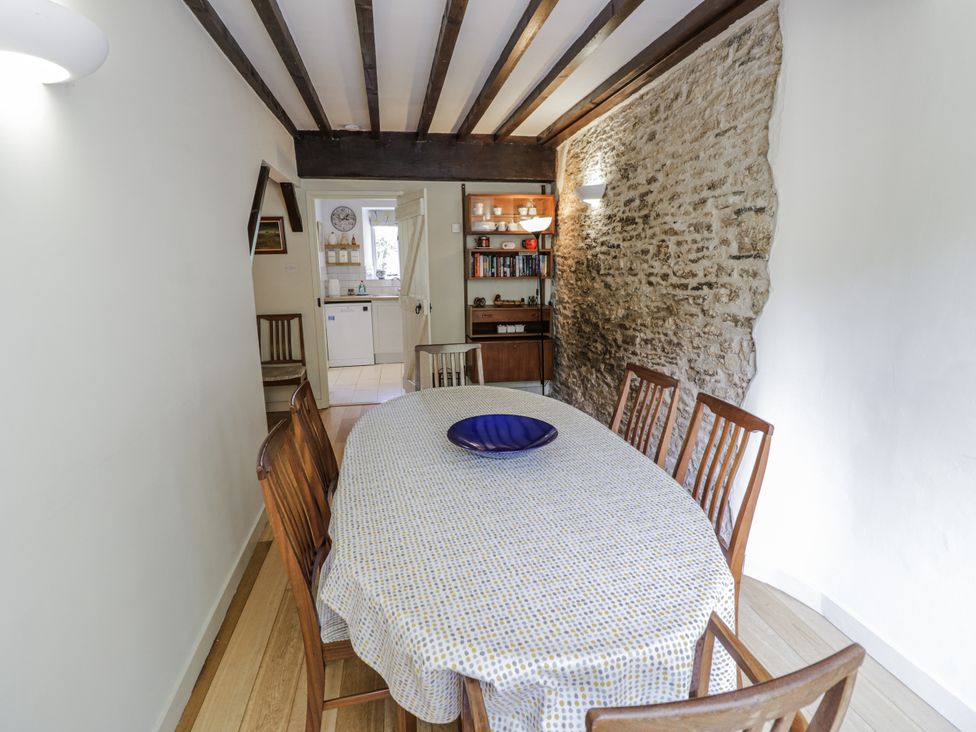 A dining room with a table and chairs at Dairy Cottage in Witney