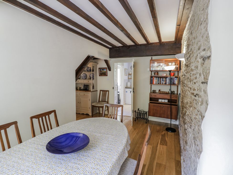 A dining room with a table and chairs at Dairy Cottage in Witney