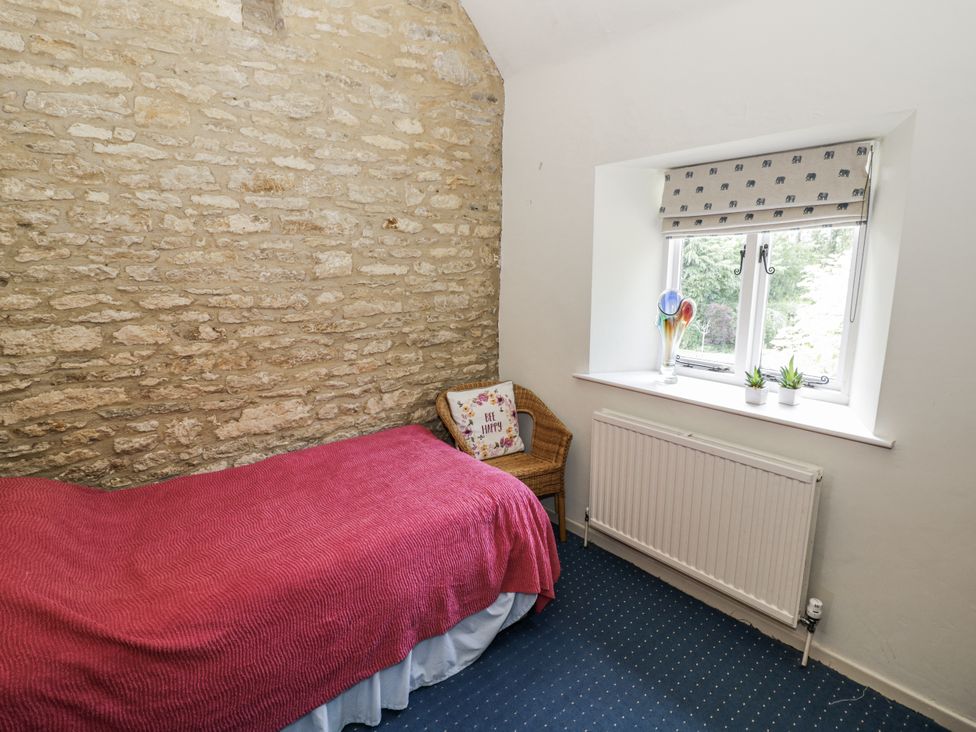 A bedroom with a single bed and window at Dairy Cottage in Witney