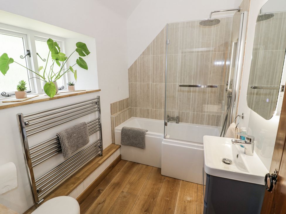 A bathroom with a bath and shower at Dairy Cottage in Witney