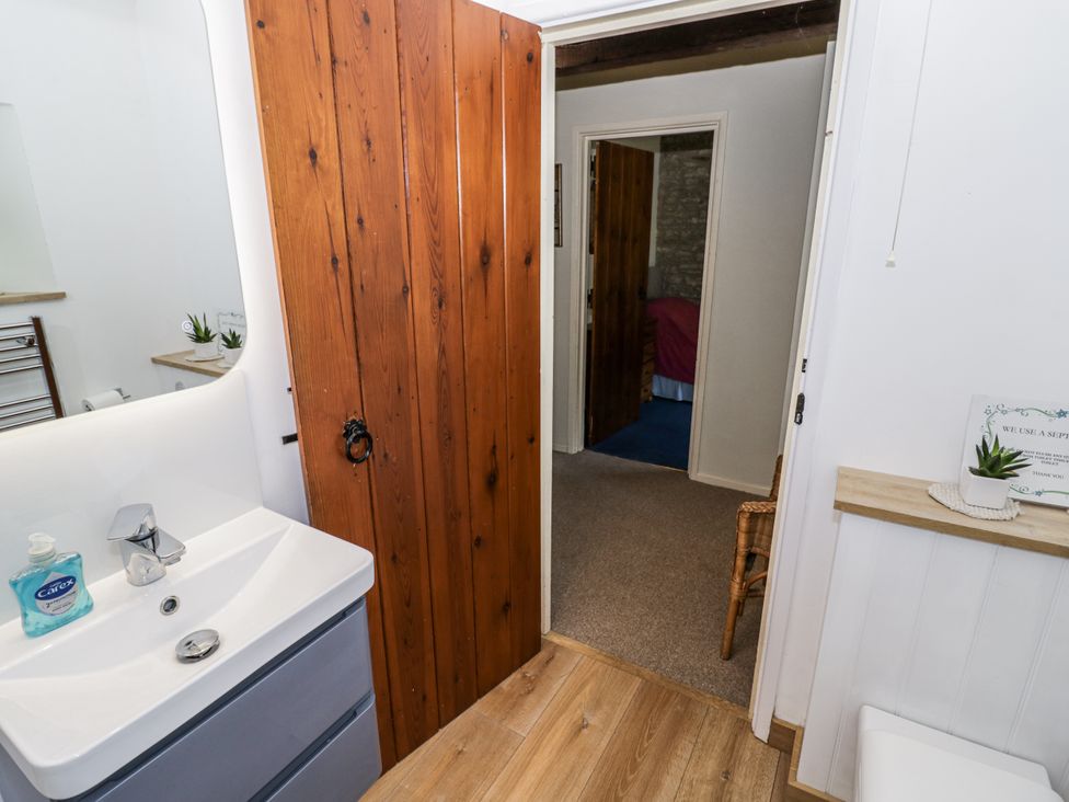 A bathroom with a sink and doorway at Dairy Cottage in Witney