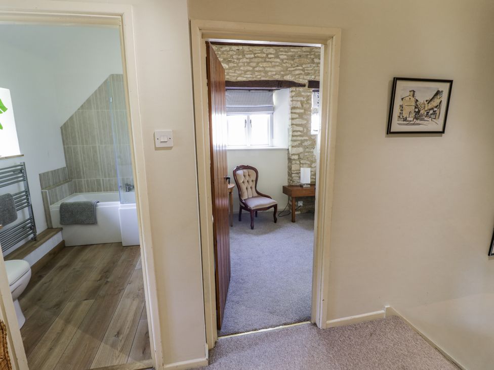 A hallway with access to a bathroom and another room at Dairy Cottage in Witney