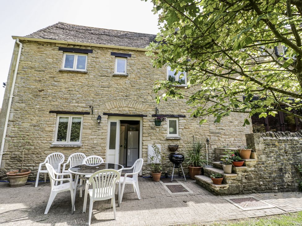 An outdoor area with a table and chairs at Dairy Cottage in Witney
