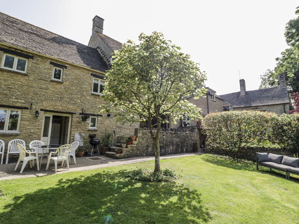 A garden with a table and chairs at Dairy Cottage Witney