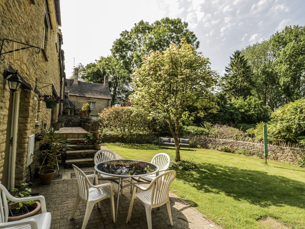 A garden with a table and chairs at Dairy Cottage in Witney