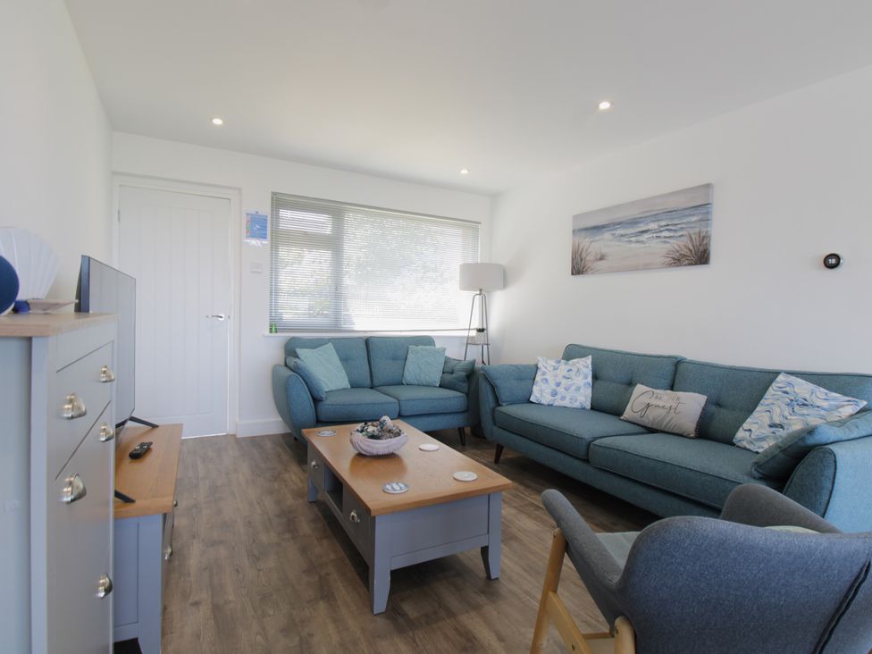 A living room featuring sofas and a television at 65 Channel View Ilfracombe