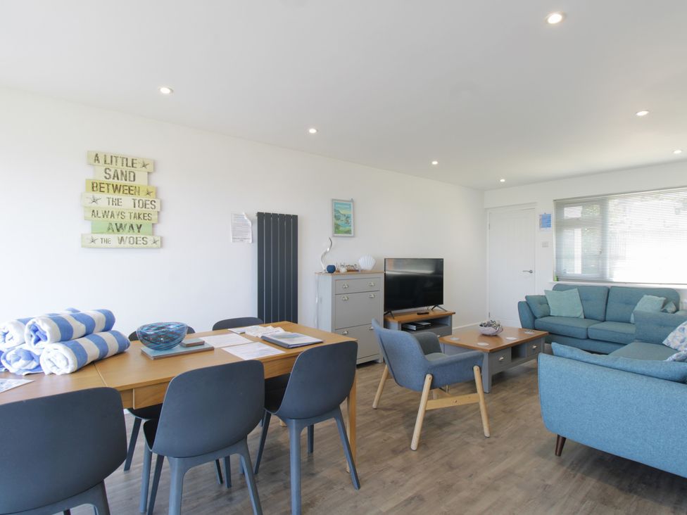 A living room with a dining area and a television at 65 Channel View Ilfracombe