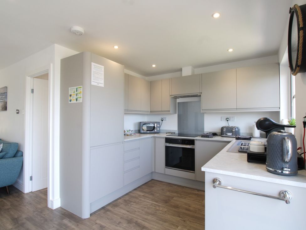A kitchen with modern appliances and cabinetry at 65 Channel View in Ilfracombe