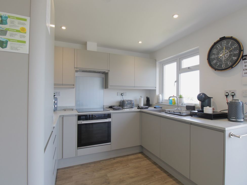 A kitchen with cabinets and appliances at 65 Channel View, Ilfracombe