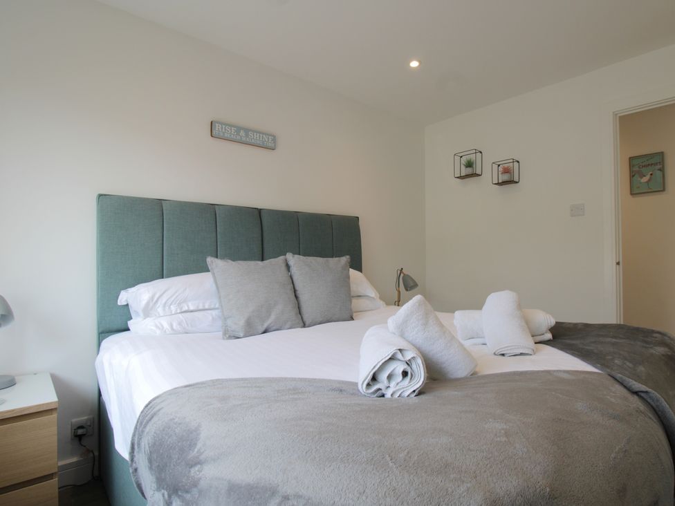 A bedroom with a bed and decorative items at 65 Channel View in Ilfracombe