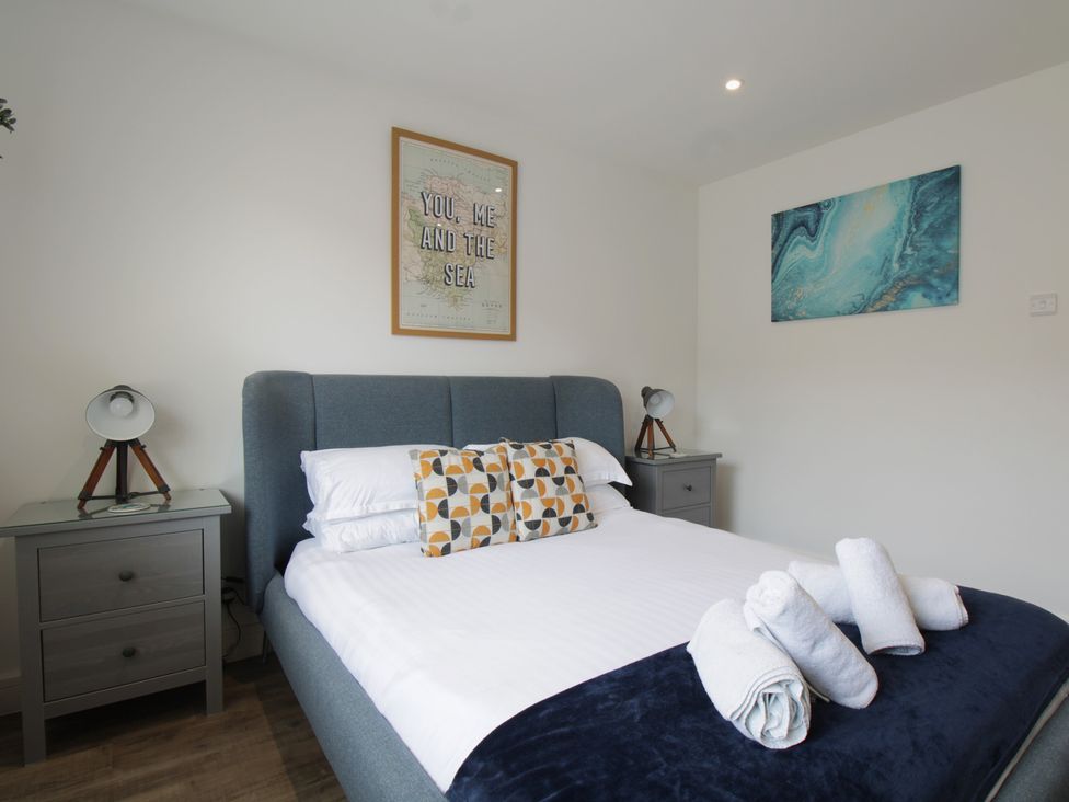 A bedroom with a bed and wall art at 65 Channel View in Ilfracombe