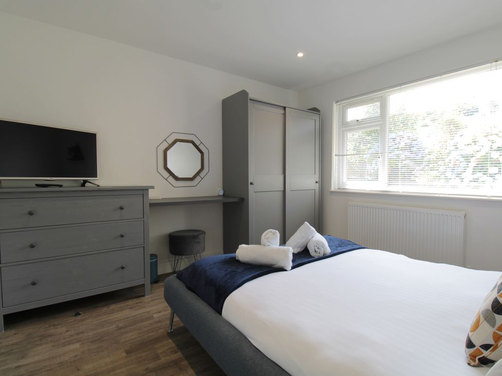 A bedroom with a bed and television at 65 Channel View Ilfracombe