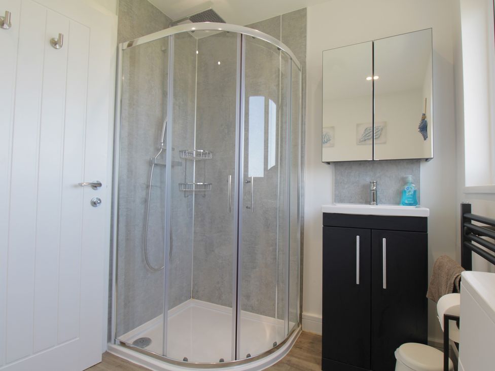 A bathroom with a shower and sink at 65 Channel View Ilfracombe