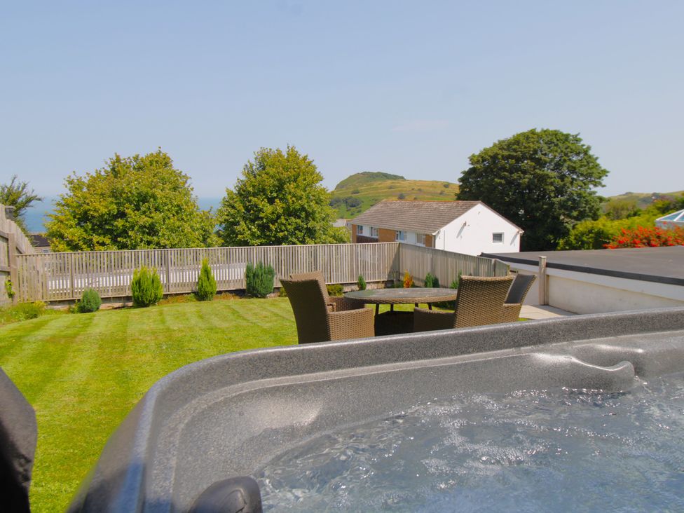 A garden with a hot tub and outdoor seating at 65 Channel View Ilfracombe