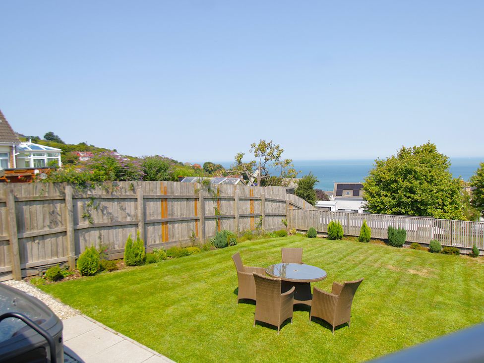 A garden with a table and chairs at 65 Channel View in Ilfracombe