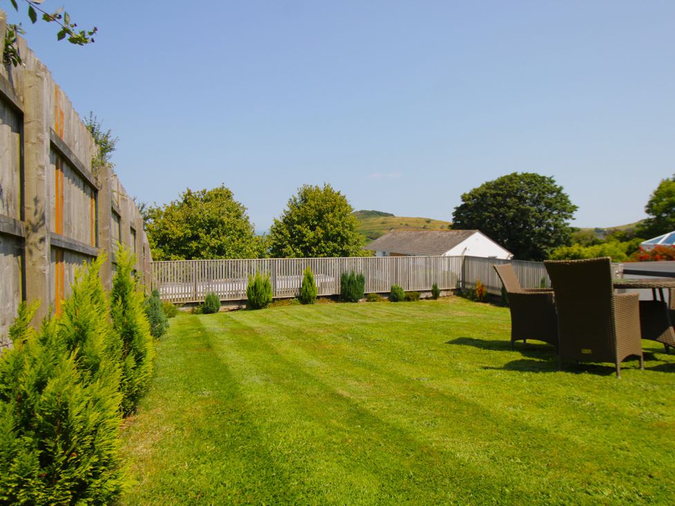 A garden with grass and seating area at 65 Channel View Ilfracombe