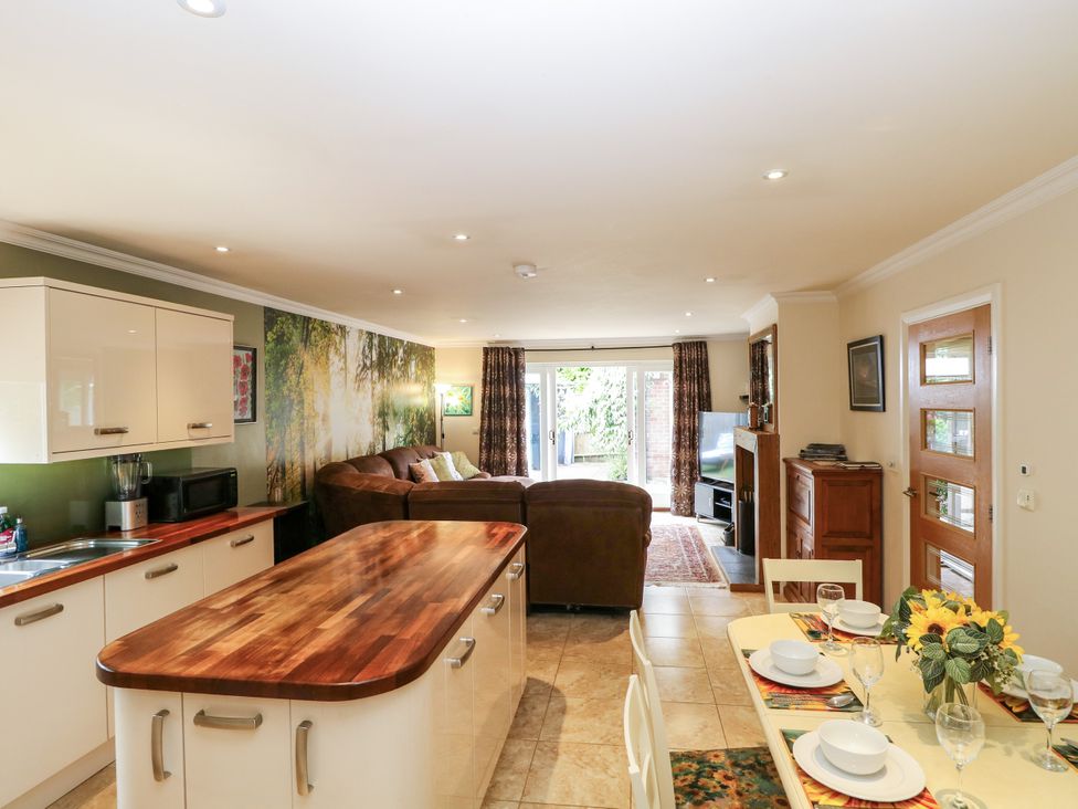 A kitchen and living room area with a sofa at Birch Cottage in Brundall