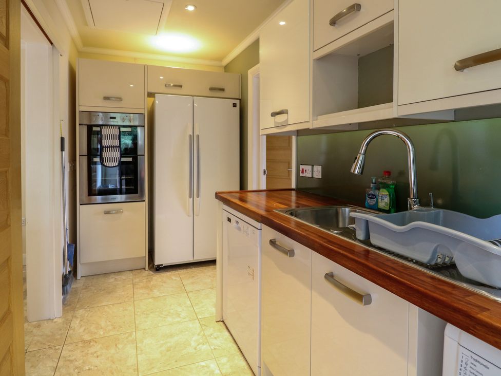 A kitchen with appliances including a fridge and oven at Birch Cottage in Brundall