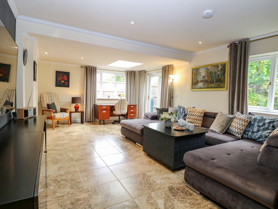 A living room with a sofa and coffee table at Birch Cottage in Brundall