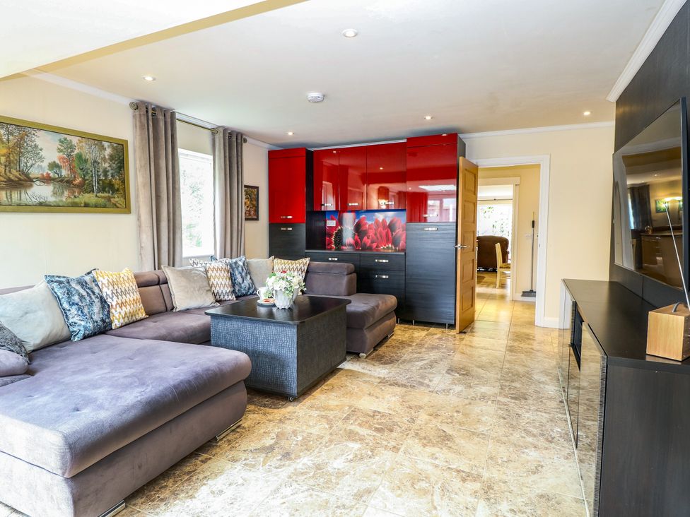 A living room with a sectional sofa and coffee table at Birch Cottage in Brundall