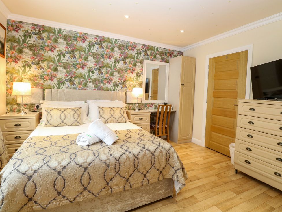 A bedroom with a double bed and dresser at Birch Cottage in Brundall