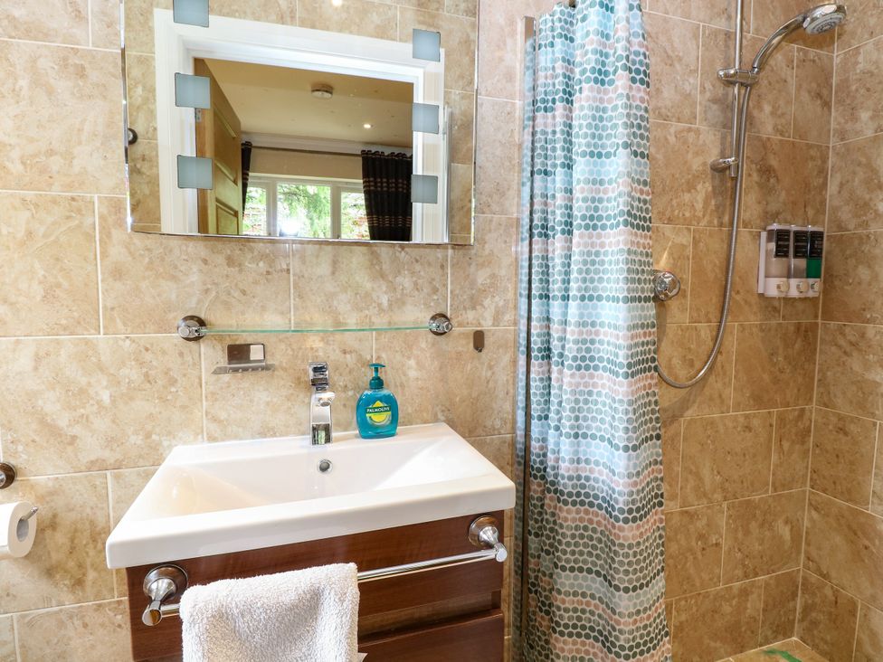A bathroom with a sink and shower at Birch Cottage in Brundall