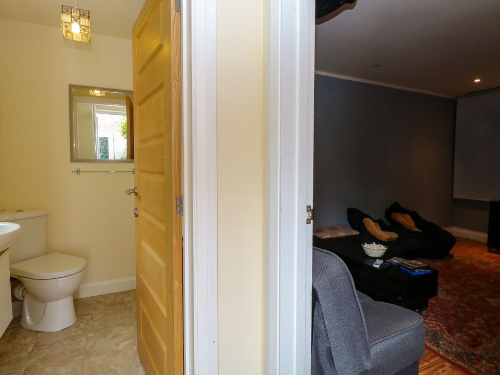 A bathroom with a toilet and a mirror at Birch Cottage in Brundall