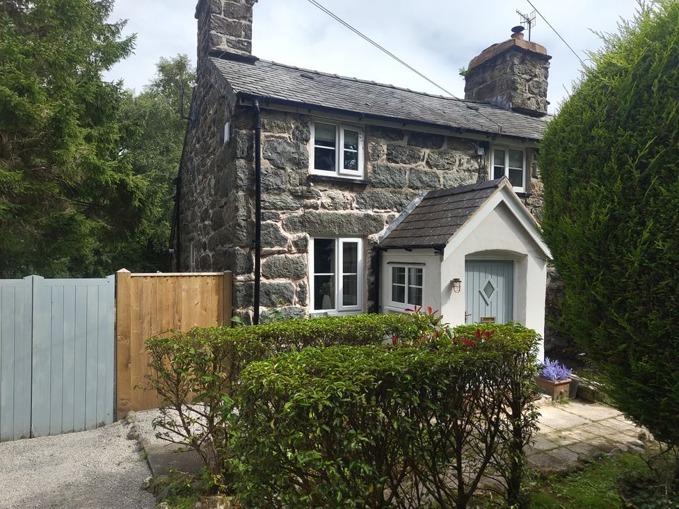 A stone cottage with a front door and garden at Islwyn Llanuwchllyn near Bala