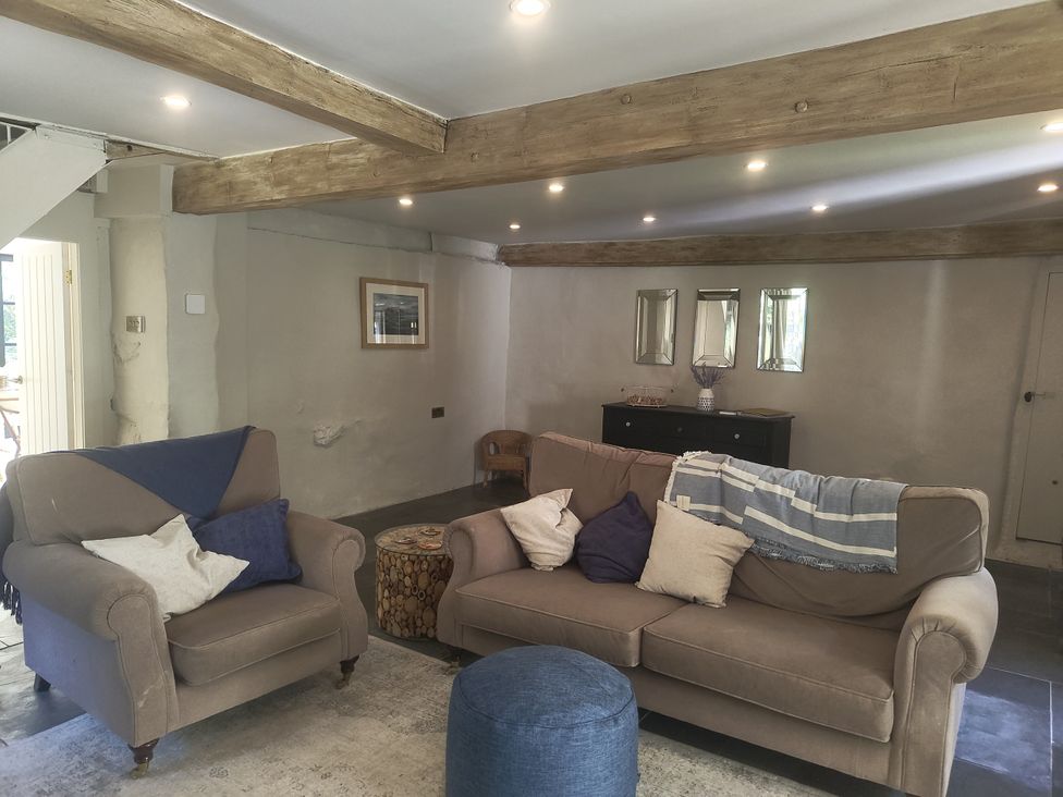 A living room with a sofa and armchair at Islwyn in Llanuwchllyn near Bala