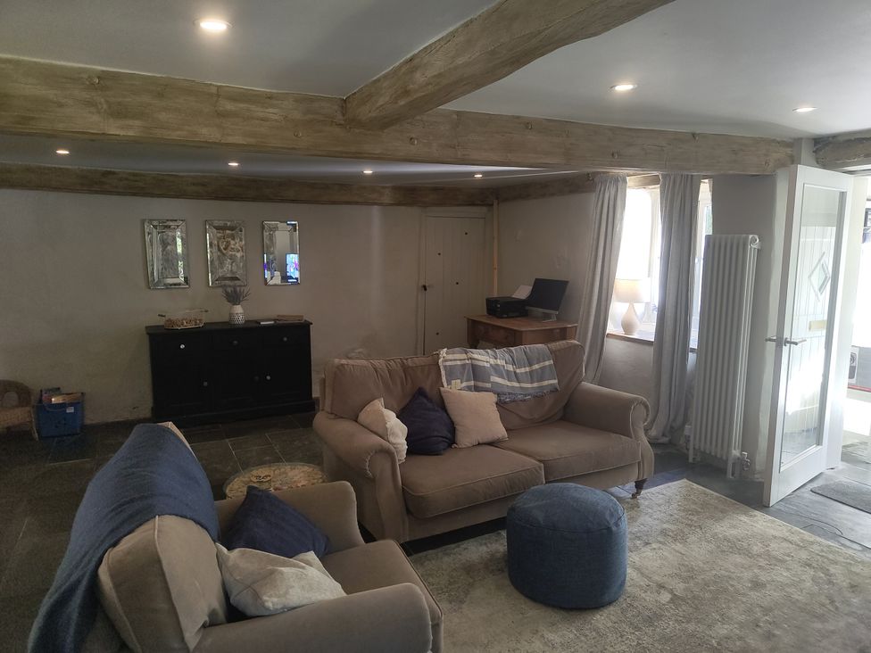 A living room with a sofa and mirrors at Islwyn Llanuwchllyn near Bala