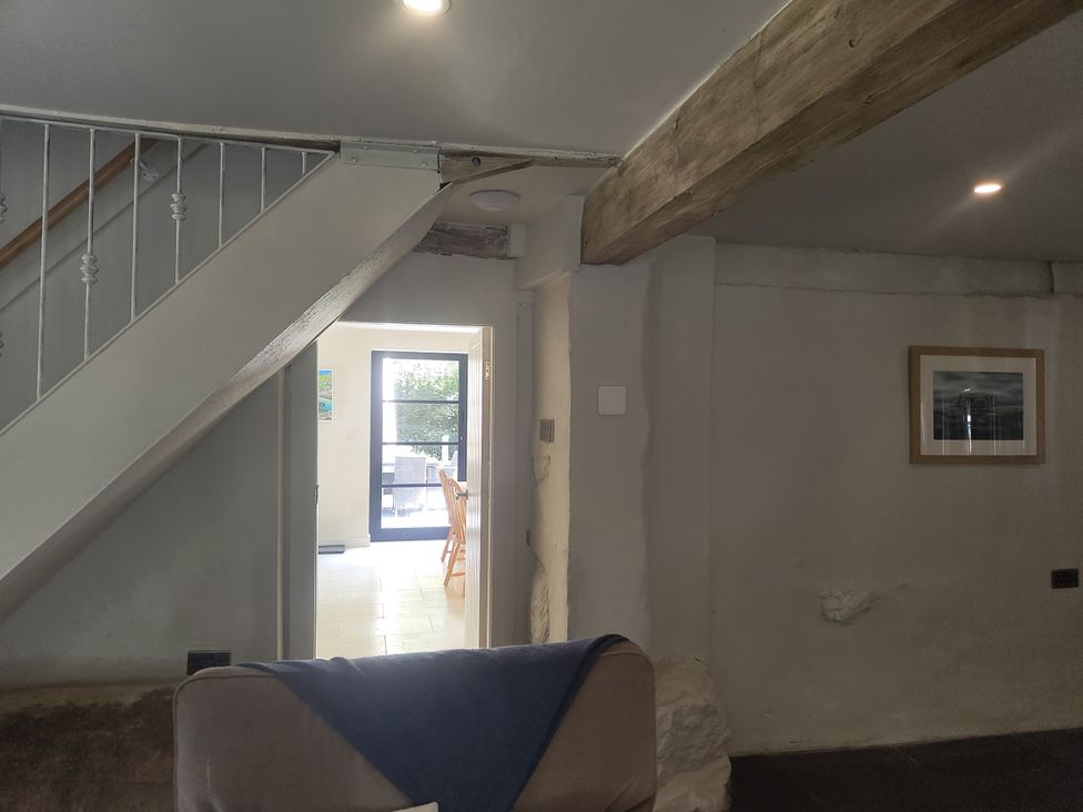 A living room with a staircase and a door to another room at Islwyn Llanuwchllyn near Bala