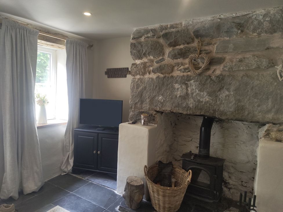 A living room with a television and wood stove at Islwyn in Llanuwchllyn near Bala