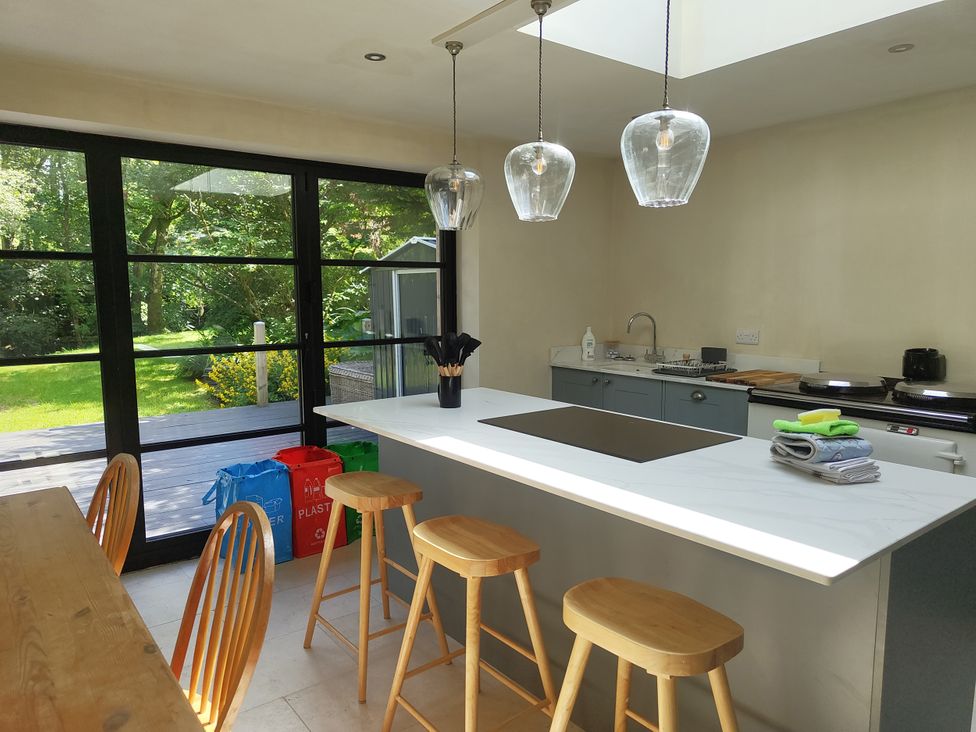 A kitchen with a countertop and bar stools at Islwyn in Llanuwchllyn near Bala