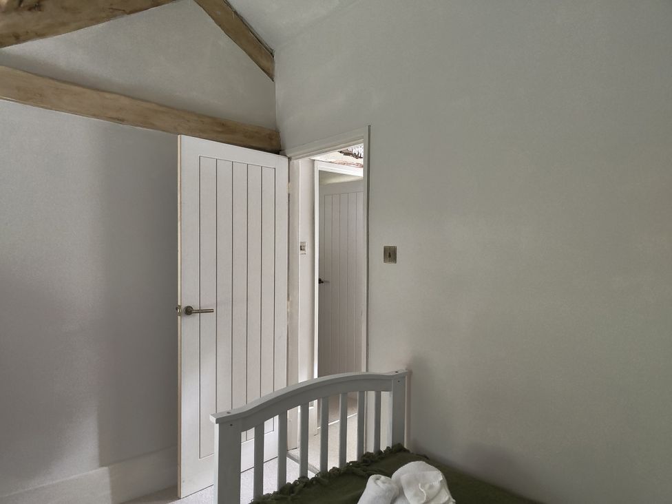 A bedroom with a bed and an open door at Islwyn in Llanuwchllyn near Bala