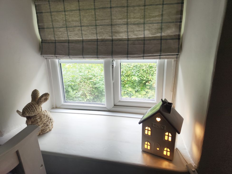 A window with a rabbit decoration and a light-up house decoration at Islwyn in Llanuwchllyn near Bala