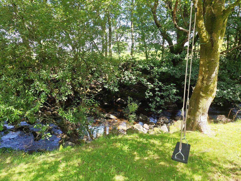 A swing hanging from a tree beside a stream at Islwyn in Llanuwchllyn near Bala